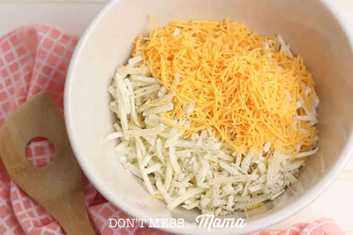 hash browns and cheese in a white mixing bowl