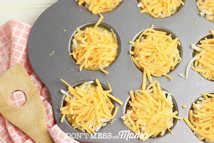 adding cheese to egg mixture in muffin tin