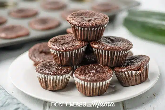 zucchini chocolate muffins stacked on a plate