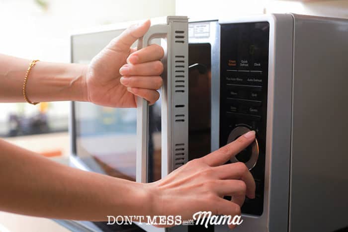 hands opening a microwave