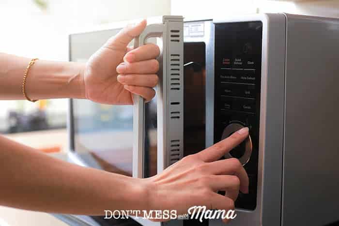 Woman pushing buttons on a microwave