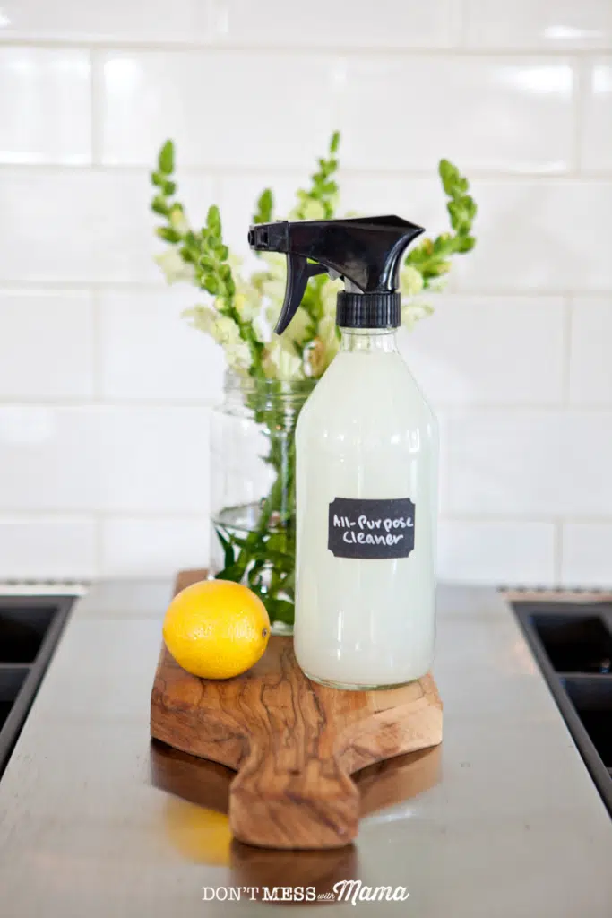 closeup of DIY Kitchen Cleaner spray bottle on a cutting board on a stovetop