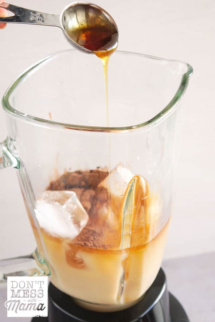 Adding honey to a blender to make iced coffee
