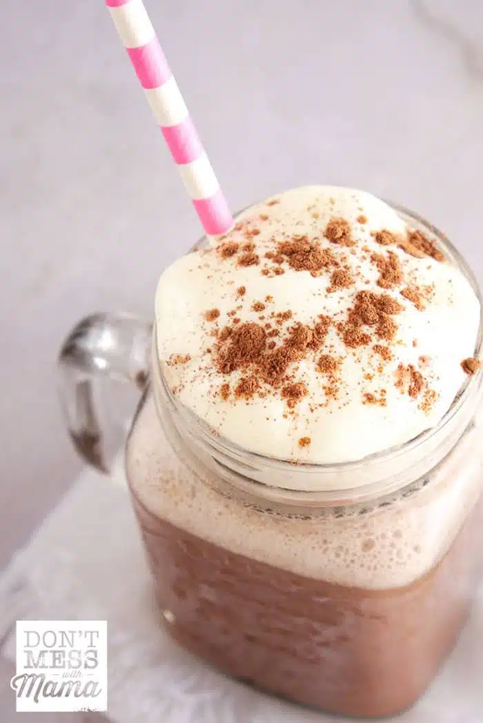 overview of iced coffee in a glass topped with cinnamon powder