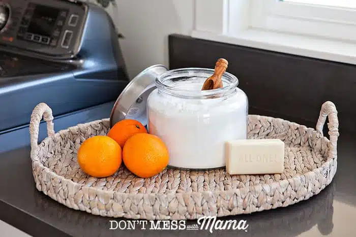 Closeup of DIY laundry detergent with orange and a bar of soap in the background