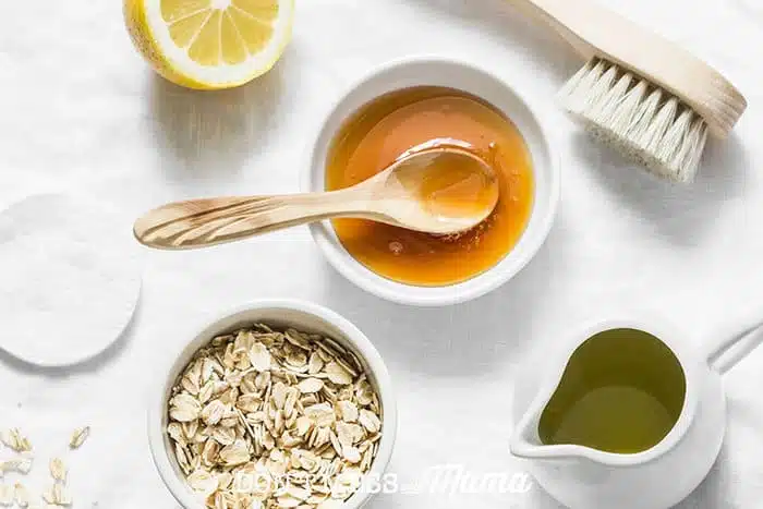 Closeup of honey, lemon, oats, olive oil and brush to make DIY beauty products