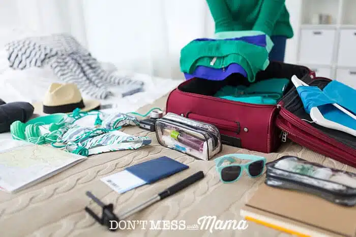 Woman packing for a trip with luggage on a bed