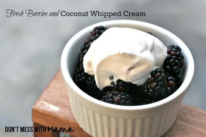 Fresh Berries with Coconut Whipped Cream on top in a small white ramekin