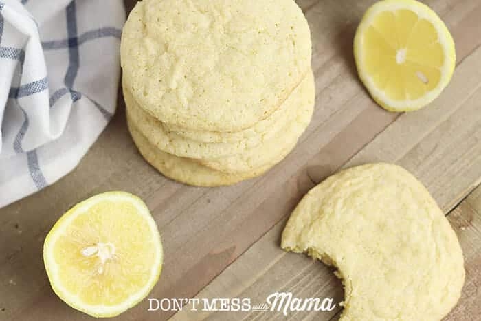 Gluten-Free Lemon Cookies piled on a cutting board with lemon slices in the background