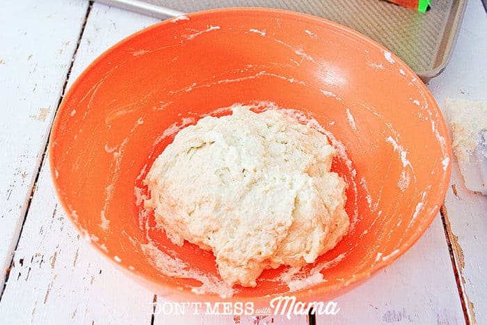 gluten-free pizza dough in an orange bowl