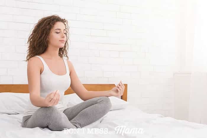 Woman on bed in lotus meditation position