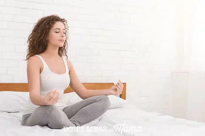 Woman on bed in lotus meditation position
