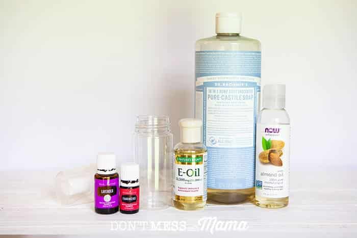 Close up of bottles of essential oil, castile soap, vitamin E oil, and almond oil with a foaming pump bottle