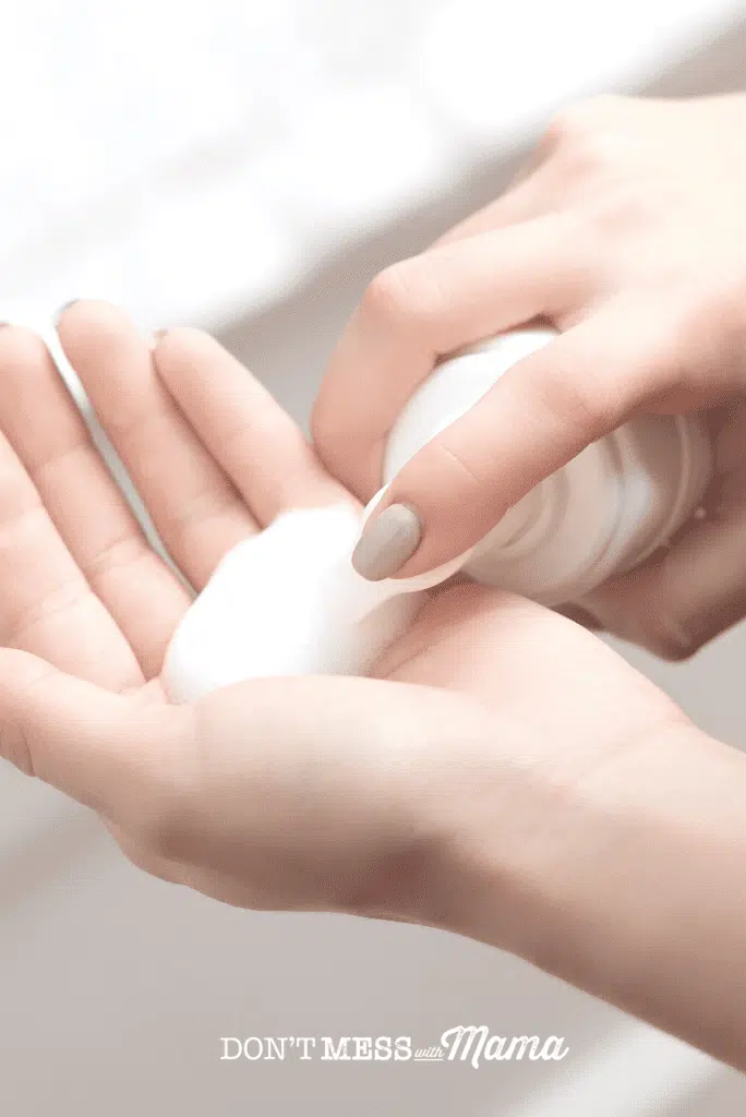hand with dollop of white foaming face wash