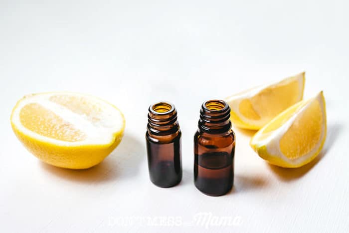 clean essential oil bottles next to slices of lemon