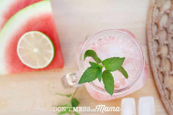 watermelon mojito in a glass with fresh mint and ice on a table