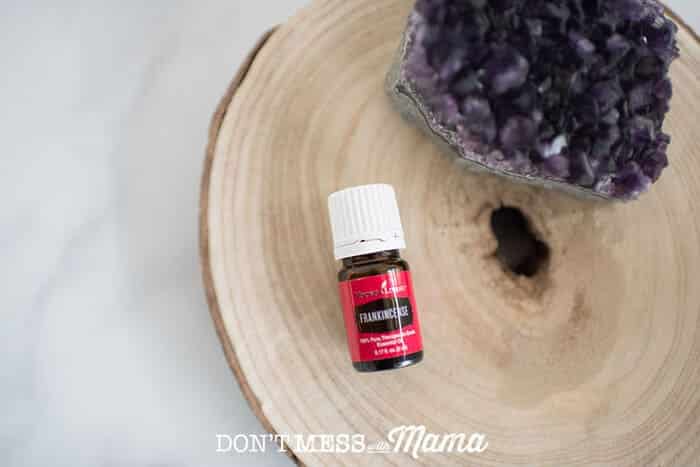 Closeup of Frankincense essential oil on a table with amethyst crystal