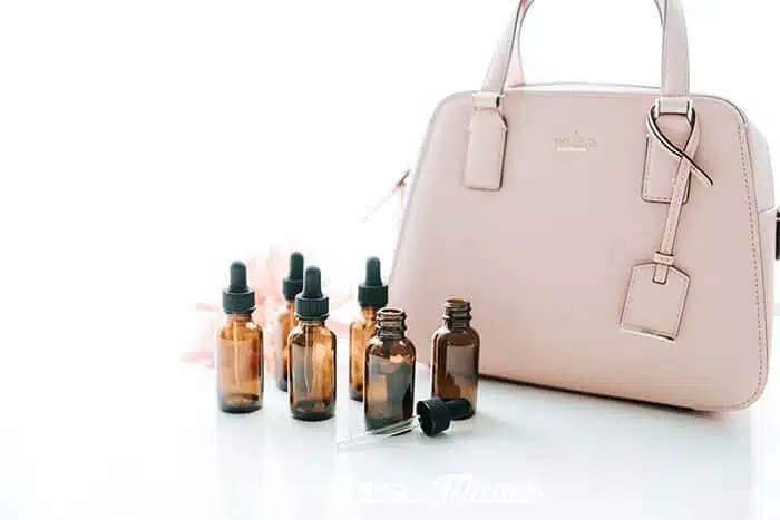 Closeup of essential oil bottle next to a purse