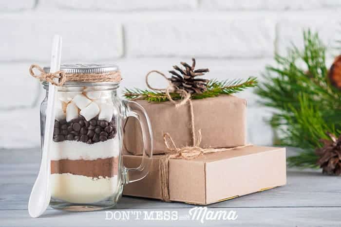 Closeup of hot chocolate mix in a mason jar with presents in the background