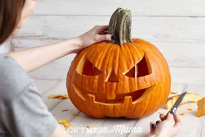 Closeup of woman carving a pumpkin