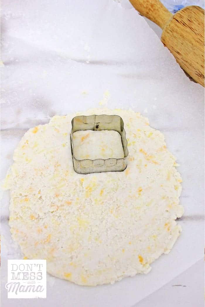 Rolled out cheese cracker dough with square cookie cutters