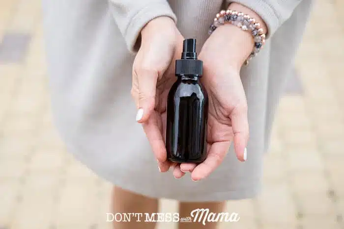 woman holding a brown bottle of sanitizer