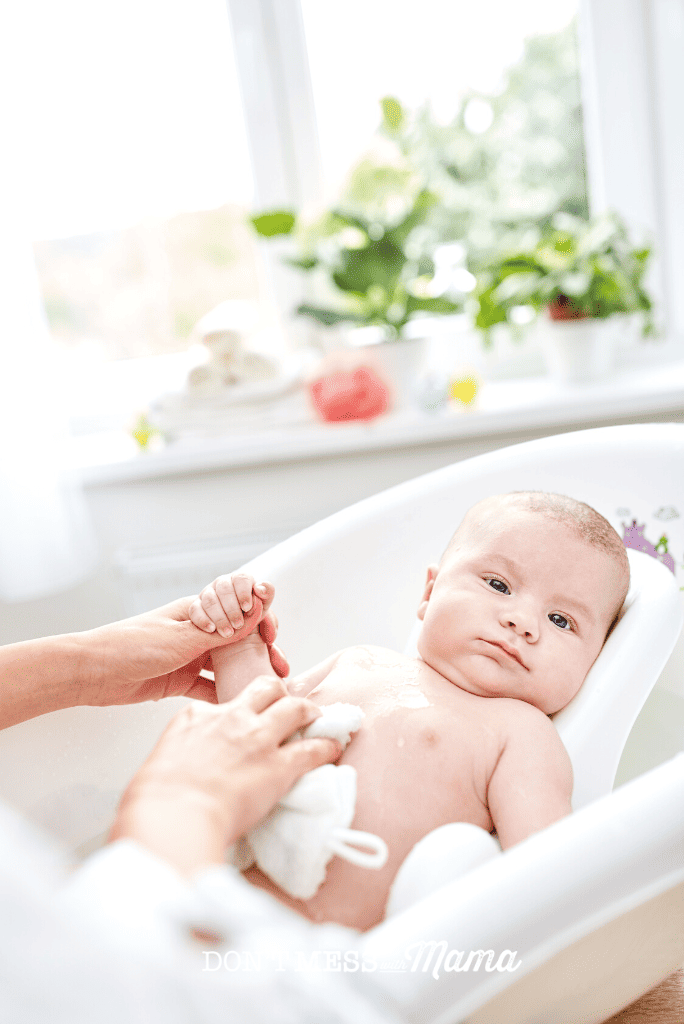 mom using natural baby shampoo on baby in bath