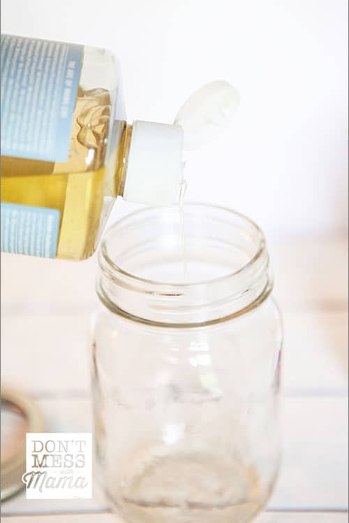 Closeup of liquid castile soap pouring into a mason jar