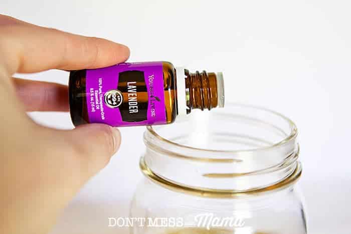 Closeup of lavender essential oil drops going into a mason jar for natural baby shampoo