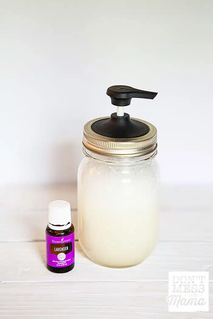 Closeup of lavender essential oil next to a mason jar with natural baby shampoo