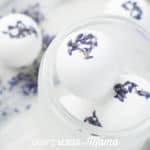 Homemade bath bombs with lavender flowers on a white surface