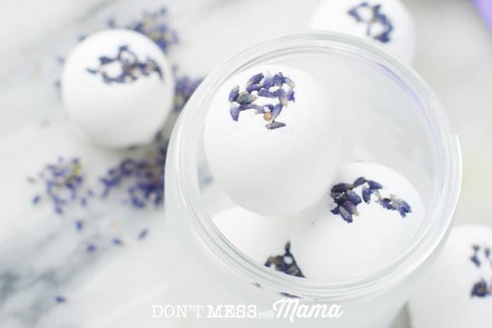 Homemade bath bombs with lavender flowers on a white surface