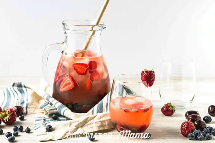 White sangria in a glass pitcher and glass with fresh fruit