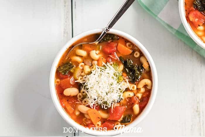 Instant Pot Minestrone soup in a white bowl topped with Parmesan cheese