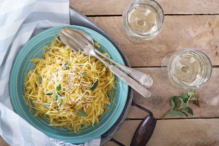 Spaghetti Squash pasta Aglio E Olio in a blue bowl on a wooden surface