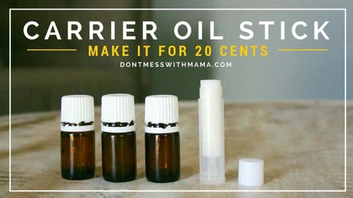 A small diy carrier oil stick on a wooden table with 3 bottles of essential oil