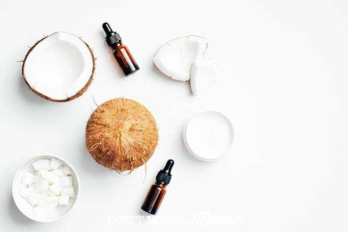 coconut oil, essential oils, homemade sunscreen on a white table