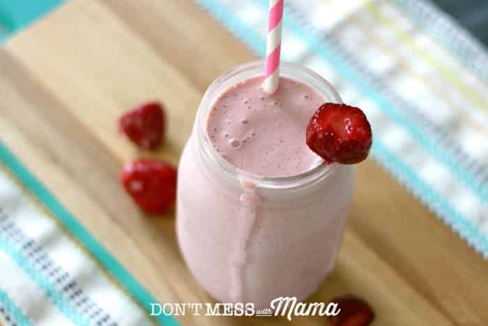 Strawberry smoothie in a glass jar topped with a straw