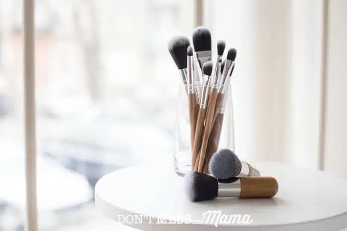 makeup brushes in a glass jar