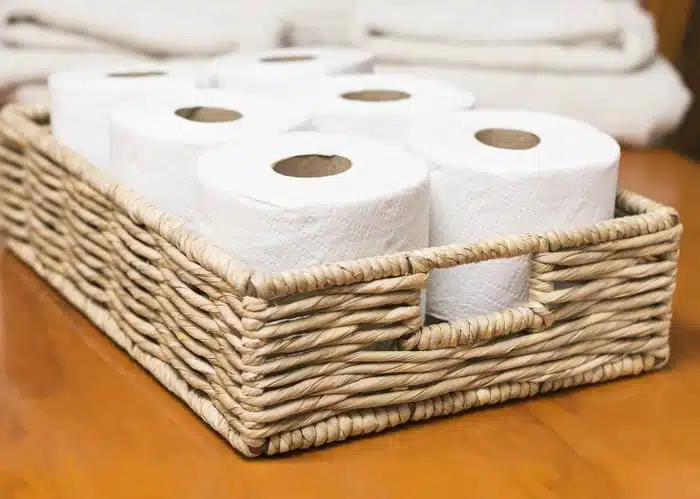 A photo of toilet rolls in a wicker basket