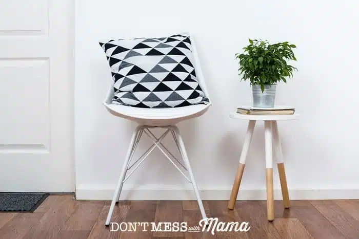 Photo of chair with a plant on a stool - minimalist living concept