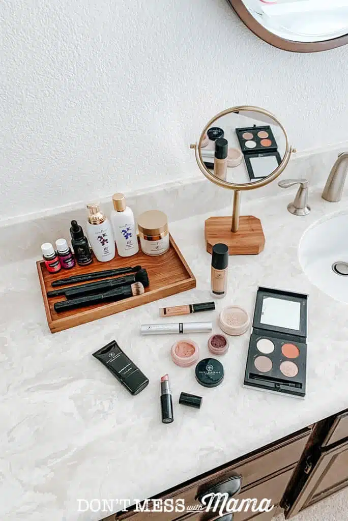Savvy Minerals lipstick, foundation powder, makeup brushes on a bathroom counter in a pretty bathroom