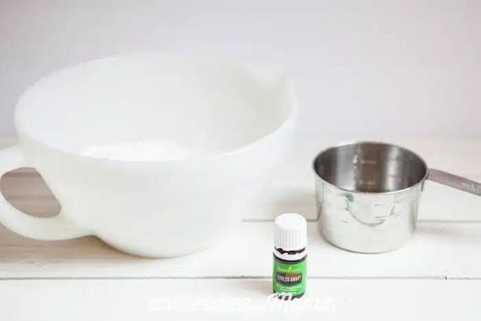 Closeup of mixing bowl, measuring cup and bottle of Stress Away essential oil
