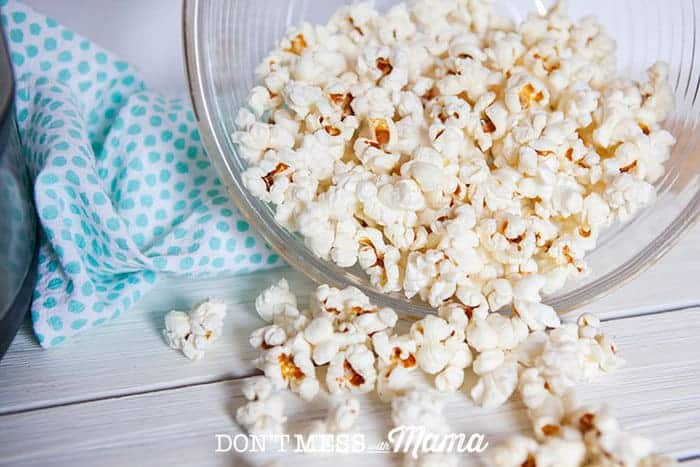 Instant Pot Popcorn spilling out of a glass bowl on it's side