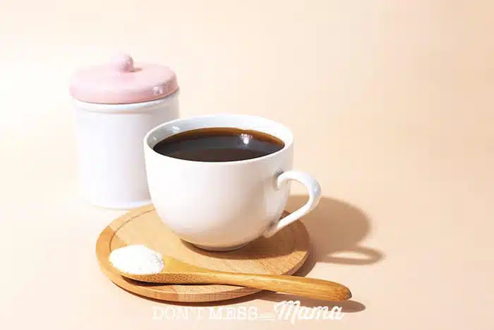 Closeup of collagen powder next to a cup of coffee