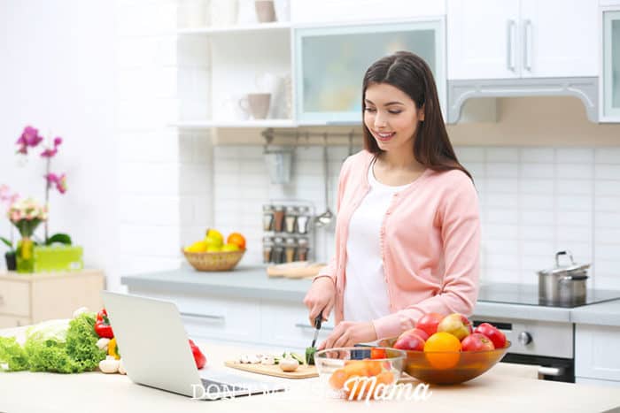 Woman in a kitchen with a laptop
