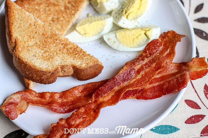 close up of bacon on a plate with boiled eggs and toast
