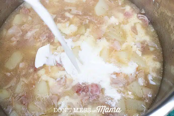 pouring half and half into the clam and potato mixture