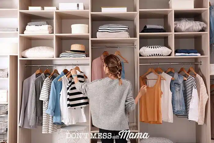 Woman arranging clothes in a closet