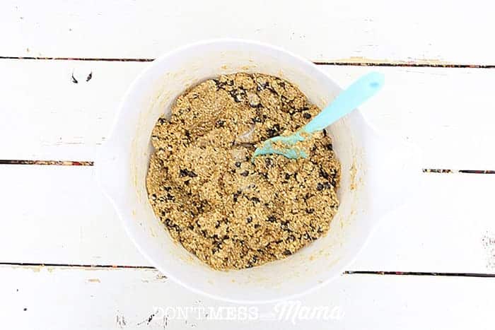 mixing rolled oats, chocolate chips, and ingredients for granola bars in a bowl